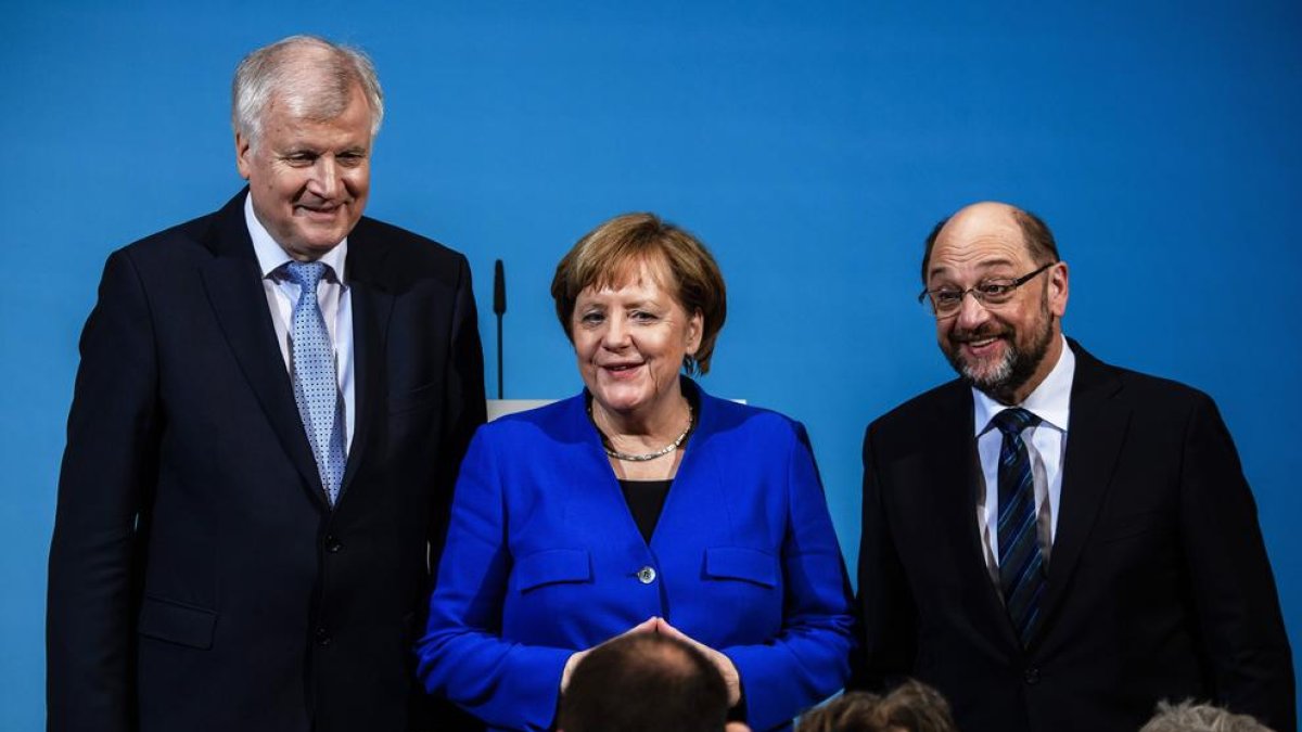 Angela Merkel, ahir, amb el líder de l’SPD, Martin Schulz (dreta), i el de la CSU, Horst Seehofer.