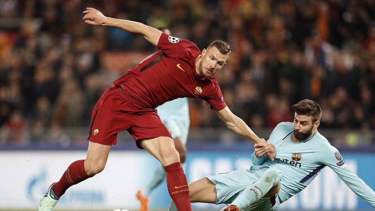 Gerard Piqué comete un claro penalti al agarrar a Edin Dzeko, una acción que permitió al capitán romano De Rossi marcar el 2-0 en la segunda mitad.