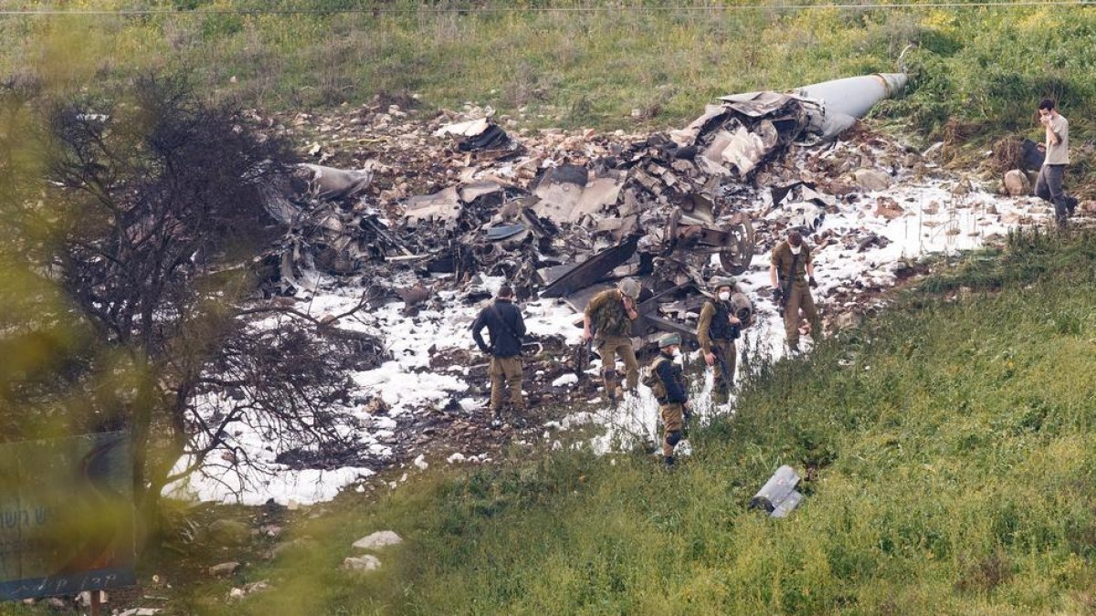 Soldats israelians inspeccionant les restes de l’F-16 abatut ahir per Bashar al-Assad.