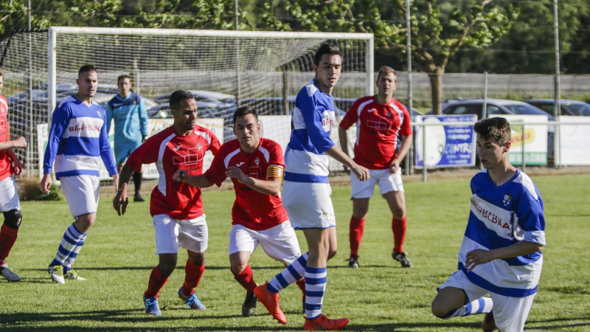 Un jugador local intenta controlar la pilota davant la pressió dels visitants.