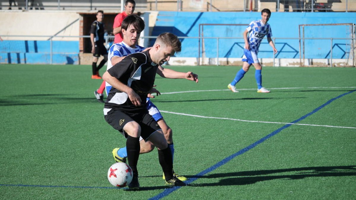 Un jugador del Brea retiene el esférico ante la presión de uno del Tamarit.