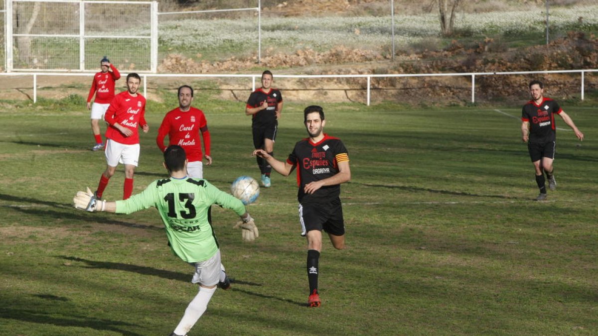 El portero del Montoliu aleja el balón ante la presión de los jugadores del Coll de Nargó.