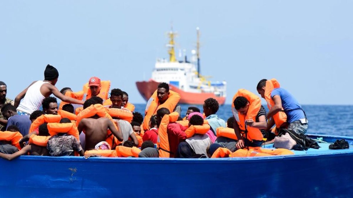 Imatge d’alguns migrants amb membres de l’equip de salvament.