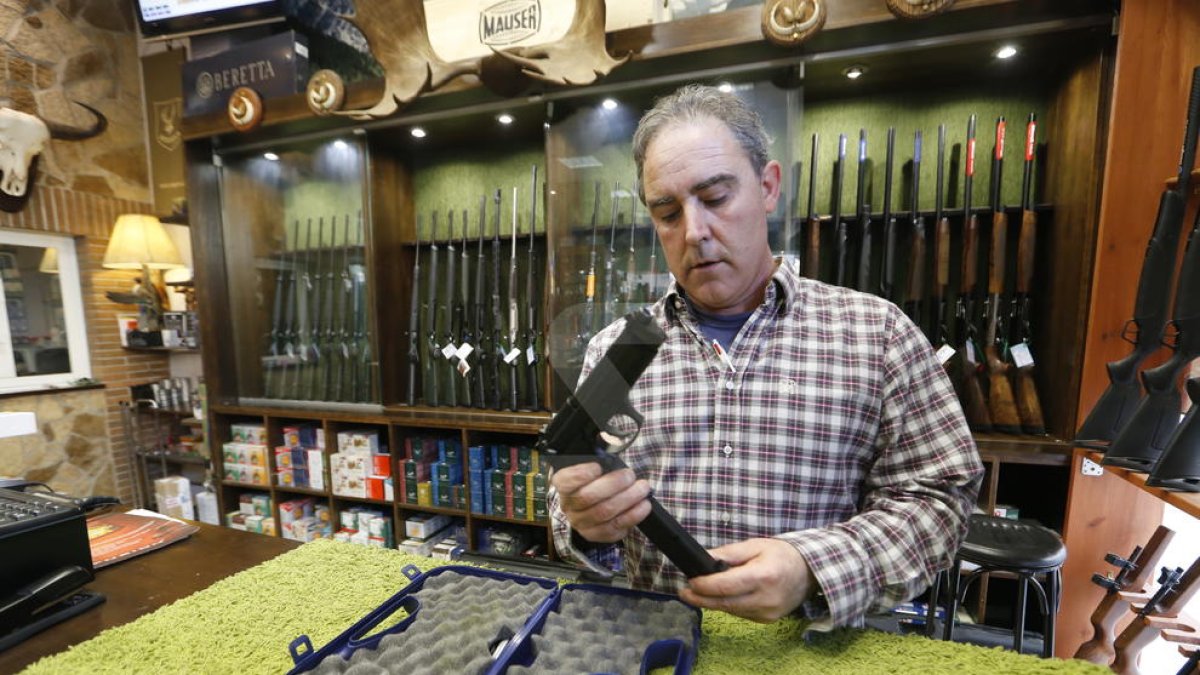 Alberto Rojo carrega una pistola a la seua armeria, ubicada a la Bordeta