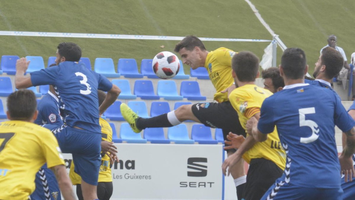 Juanto Ortuño prova de rematar una pilota de cap envoltat de contraris.