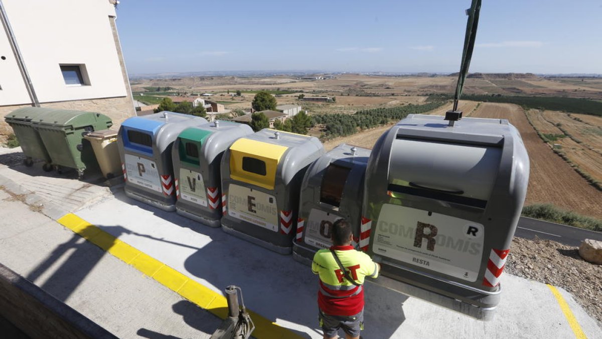 Operarios instalando los contenedores de recogida selectiva junto a los viejos en una de las islas delimitadas por el ayuntamiento de Alfés.