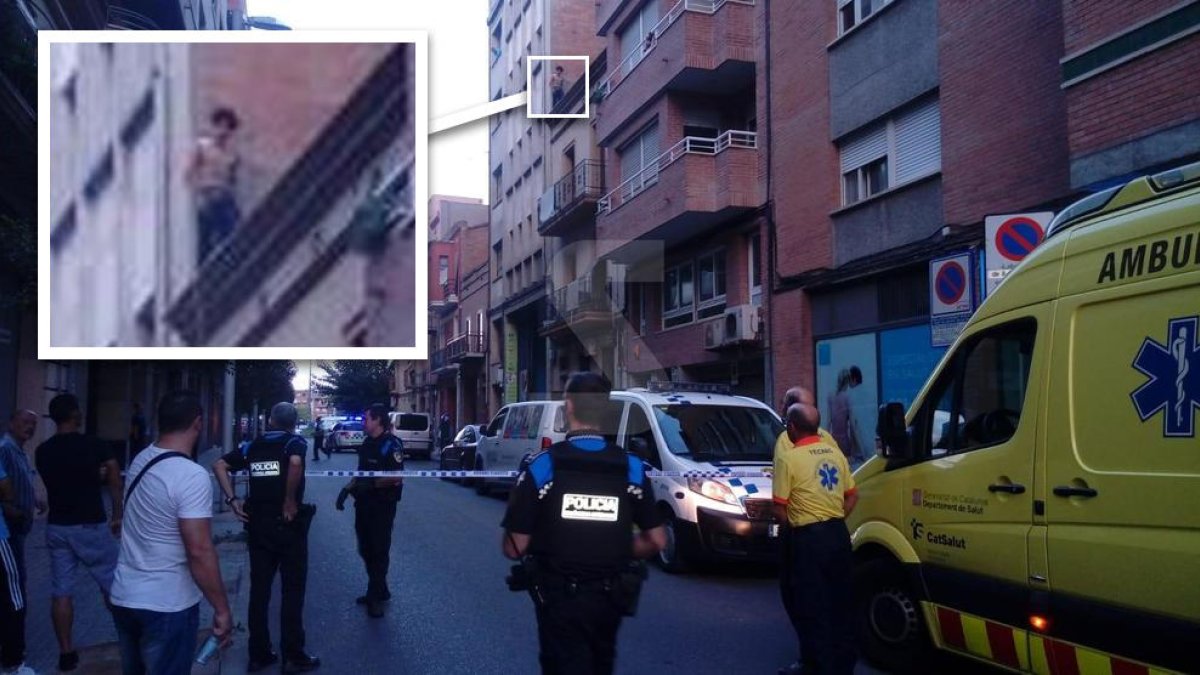 Agents i veïns, amb el carrer tallat. La fletxa indica on és el jove amb l'ampliació del requadre