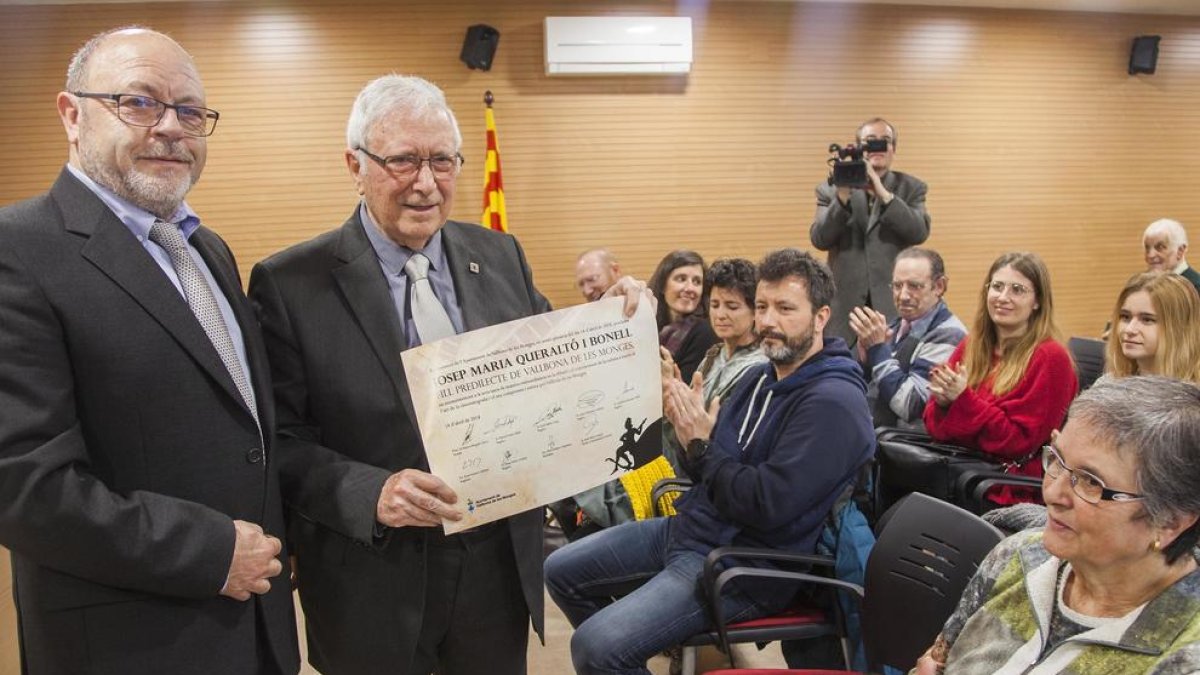 Queraltó, al costat de l’alcalde, mostra el document que l’acredita com a fill predilecte de Vallbona.