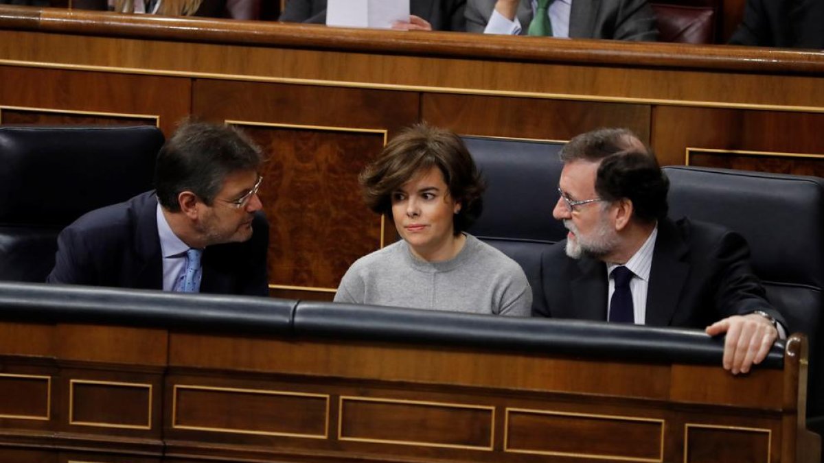 La vicepresidenta Soraya Sáenz de Santamaría, flanqueada por Rafael Catalá y Mariano Rajoy, ayer.