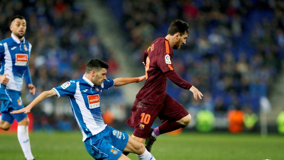 Leo Messi intenta superar l’entrada del defensa de l’Espanyol Aarón Martín en un partit gris de tot l’equip blaugrana.