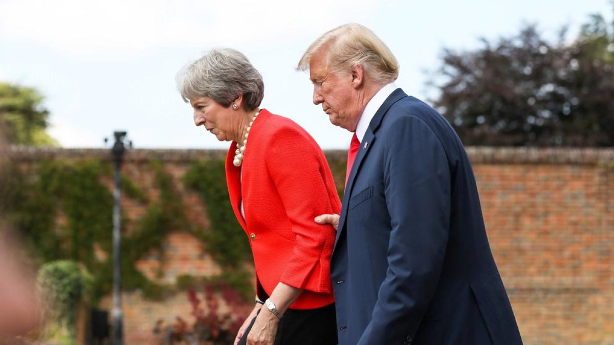 Trump agarrando del brazo a May.
