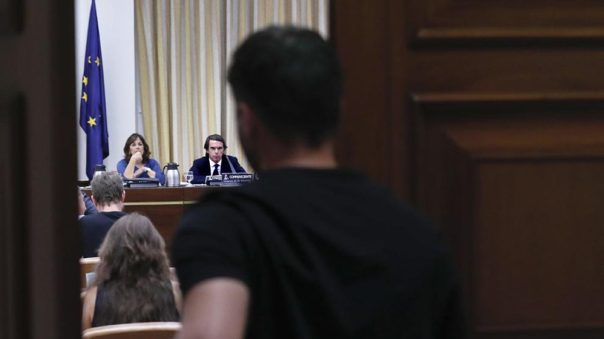 Imagen de Gabriel Rufián entrando a la sala del Congreso de los Diputados, al fondo se ve al expresidente José María Aznar.