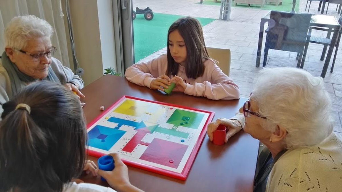 Nens de l’escola Doctor Serés d’Alpicat es reuneixen amb els usuaris de la Residència Sant Josep per jugar junts a jocs de taula.