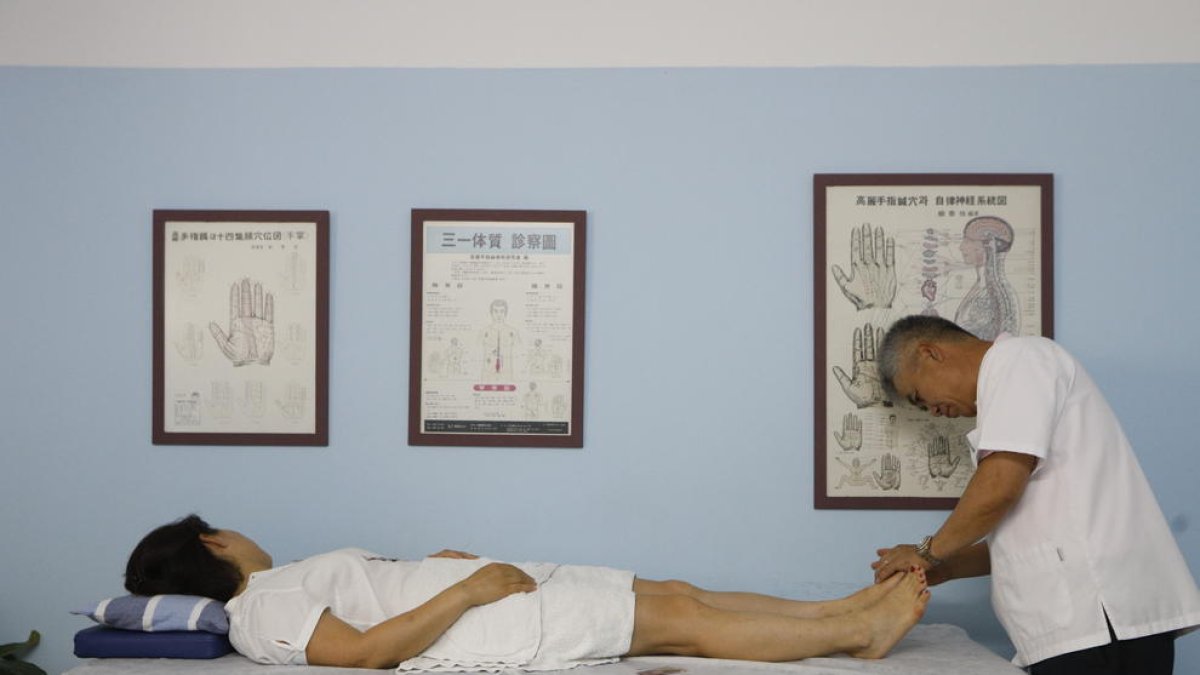 El doctor Park Chae Sun, amb un pacient al qual aplica acupuntura, medicina oriental de fa més de 2.000 anys.