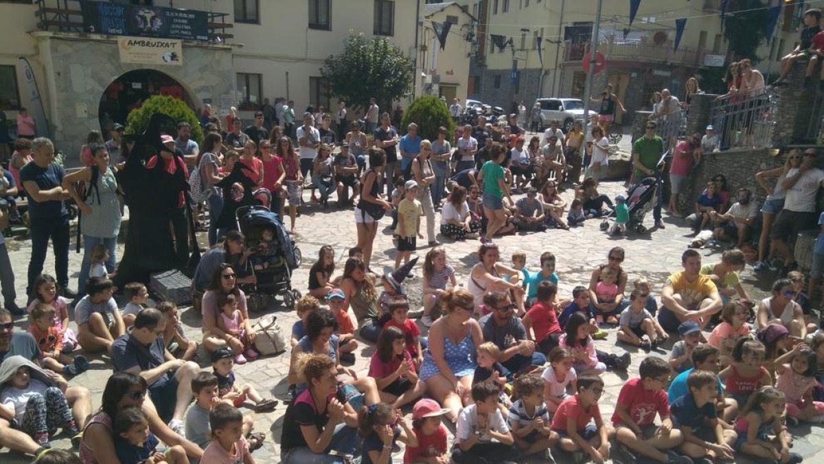 Niños y mayores durante un espectáculo de magia en la Fira de les Bruixes de Ribera de Cardós