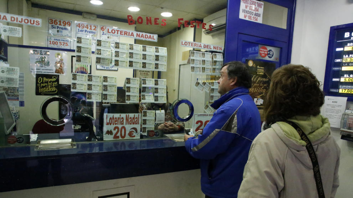 Clientes ayer eligiendo su número en la administración de lotería de la calle del Carme de Lleida.