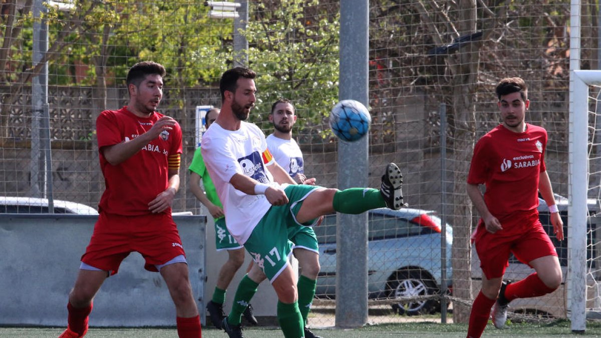 Un jugador del Balàfia controla la pilota davant de la presència de dos rivals.