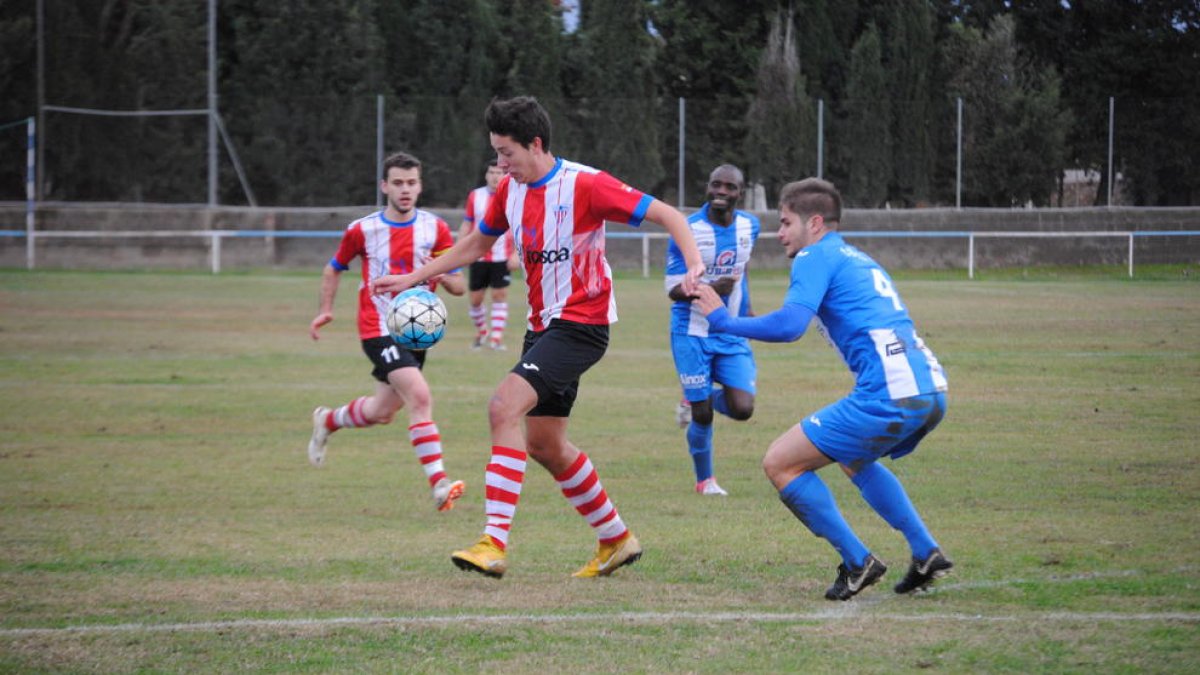 Un jugador del Pobla controla la pilota en un partit molt igualat i intens.
