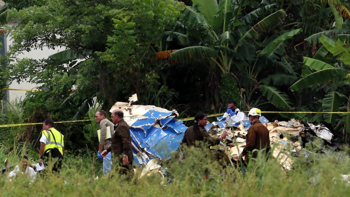 Policías y militares custodian los restos del avión accidentado en La Habana, en Cuba.
