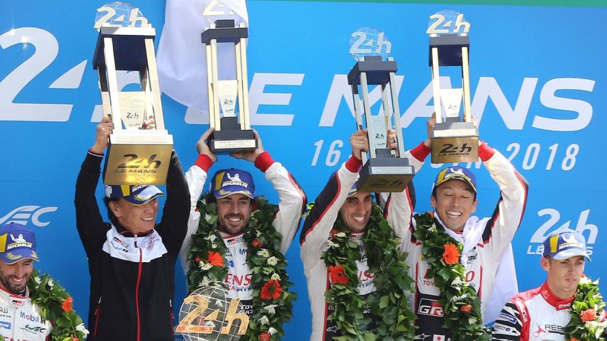 Fernando Alonso, en el podio, celebrando la victoria junto con sus compañeros de equipo.