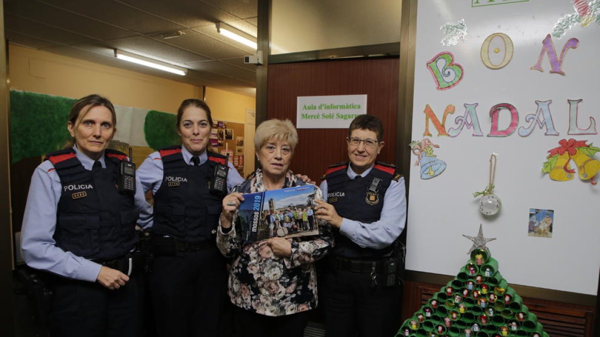 Agentes de los Mossos d’Esquadra junto con la presidenta de la asociación, Joana Espuga, ayer.