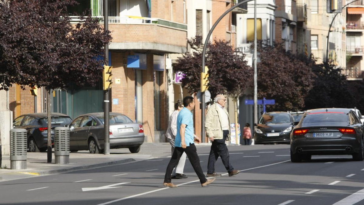 Peatones cruzando por medio de la calle Príncep de Viana.