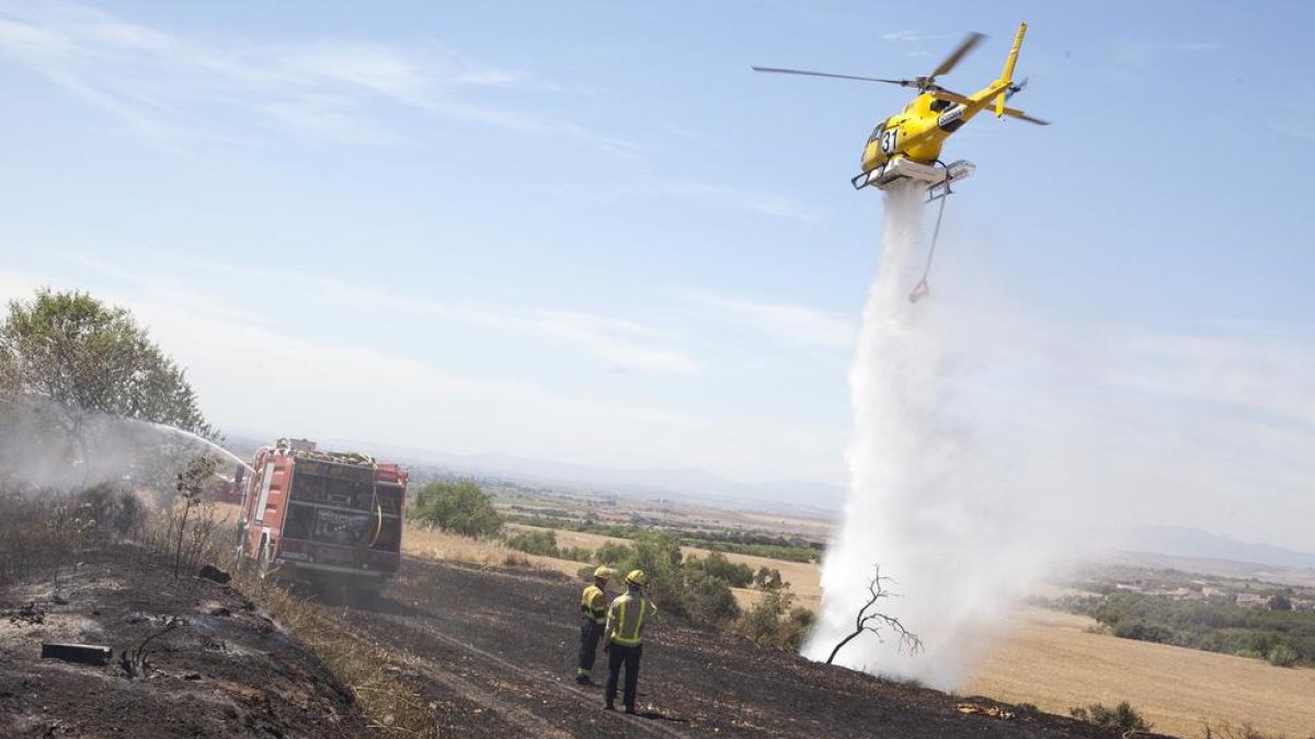 L’helicòpter descarrega aigua sobre l’incendi que es va declarar ahir a Tàrrega.