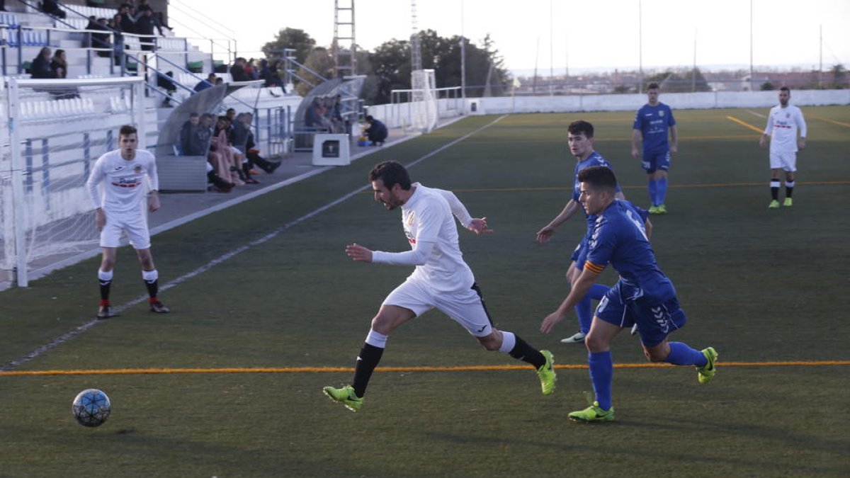 Un jugador del Borges persegueix la pilota davant la pressió de dos jugadors del Bellvitge.