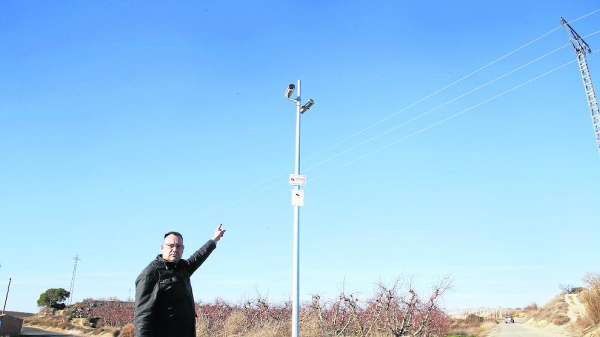 El alcalde de La Portella, Carles Català, muestra dos de las cámaras instaladas en los caminos del pueblo.