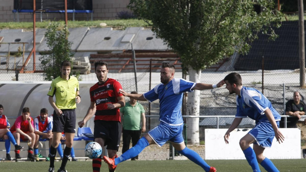 Un jugador del EFAC pelea un balón con un jugador del Sants con el colegiado al fondo.