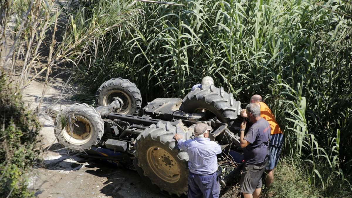 Vista del tractor volcado ayer en el camino de Vilanova de la Barca, en el municipio de Torrelameu.
