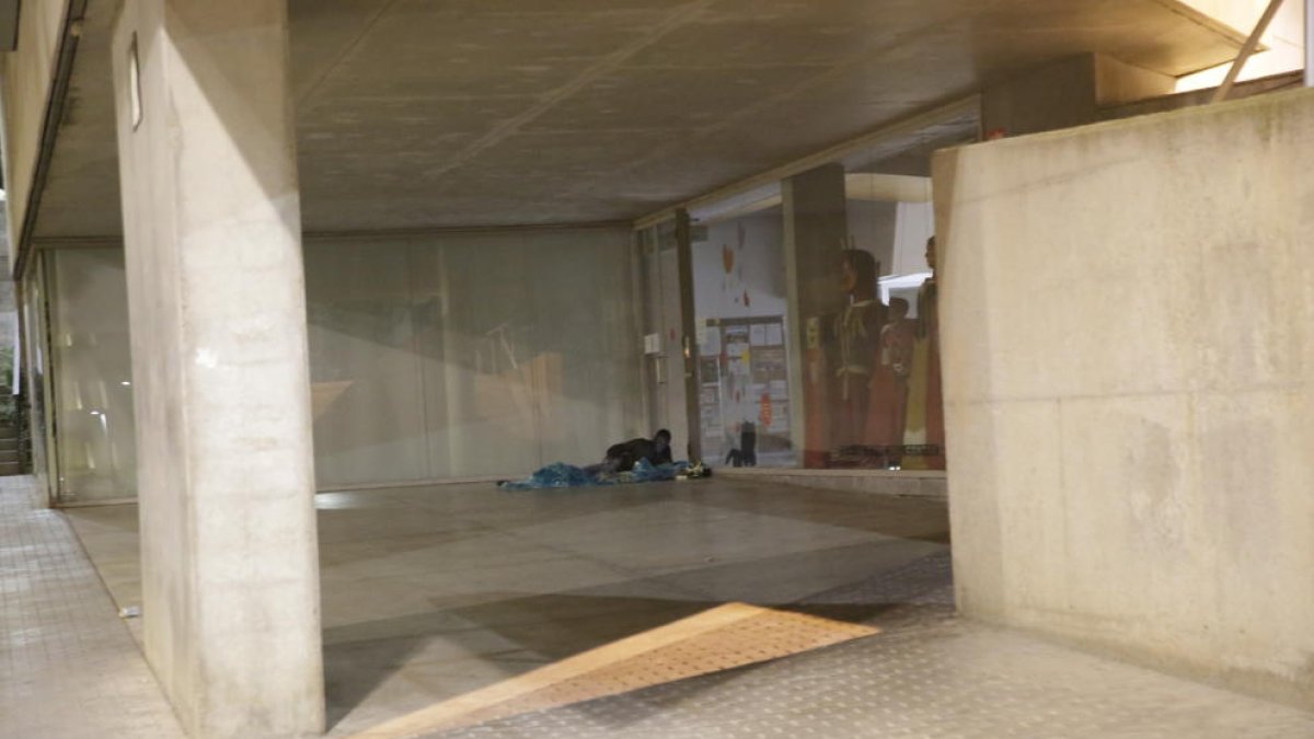 Una persona estirada al porxo del centre cívic de l’Ereta.