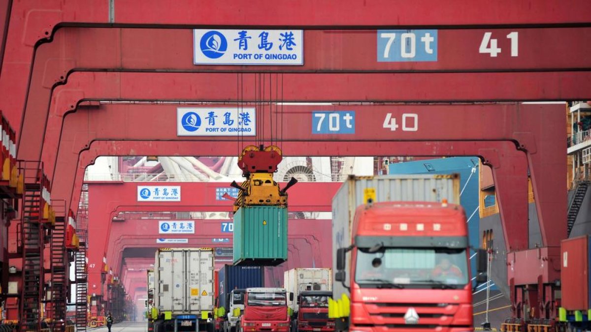 Varios camiones transportan contenedores en Qingdao.