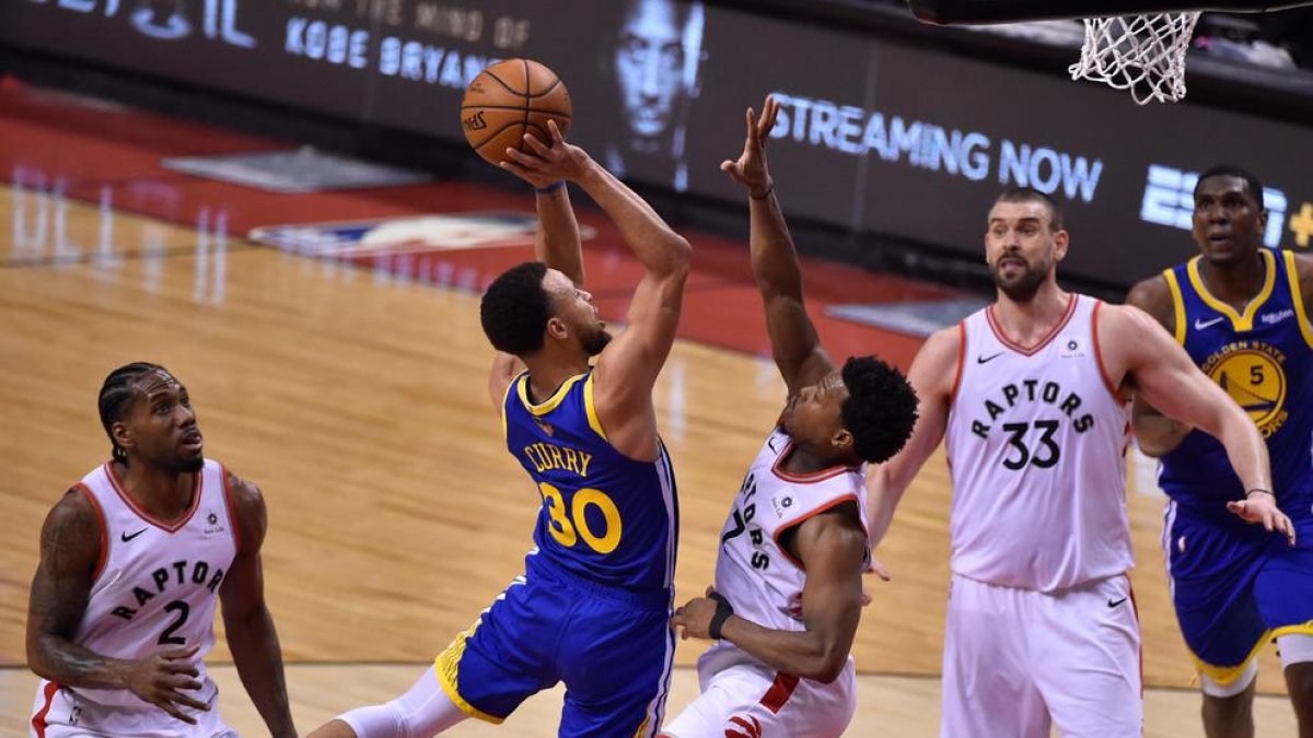 Stephen Curry intenta anotar davant de Lowry i Marc Gasol.
