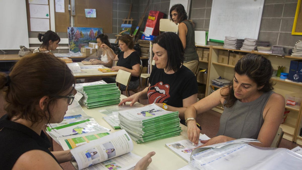 Membres de l’AMPA recullen els llibres del curs passat per revisar-los, condicionar-los i deixar-los preparats per al setembre.