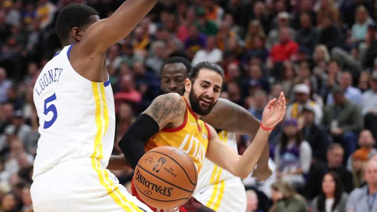 Ricky Rubio recibe la oposición de Kevon Looney, de los Warriors.