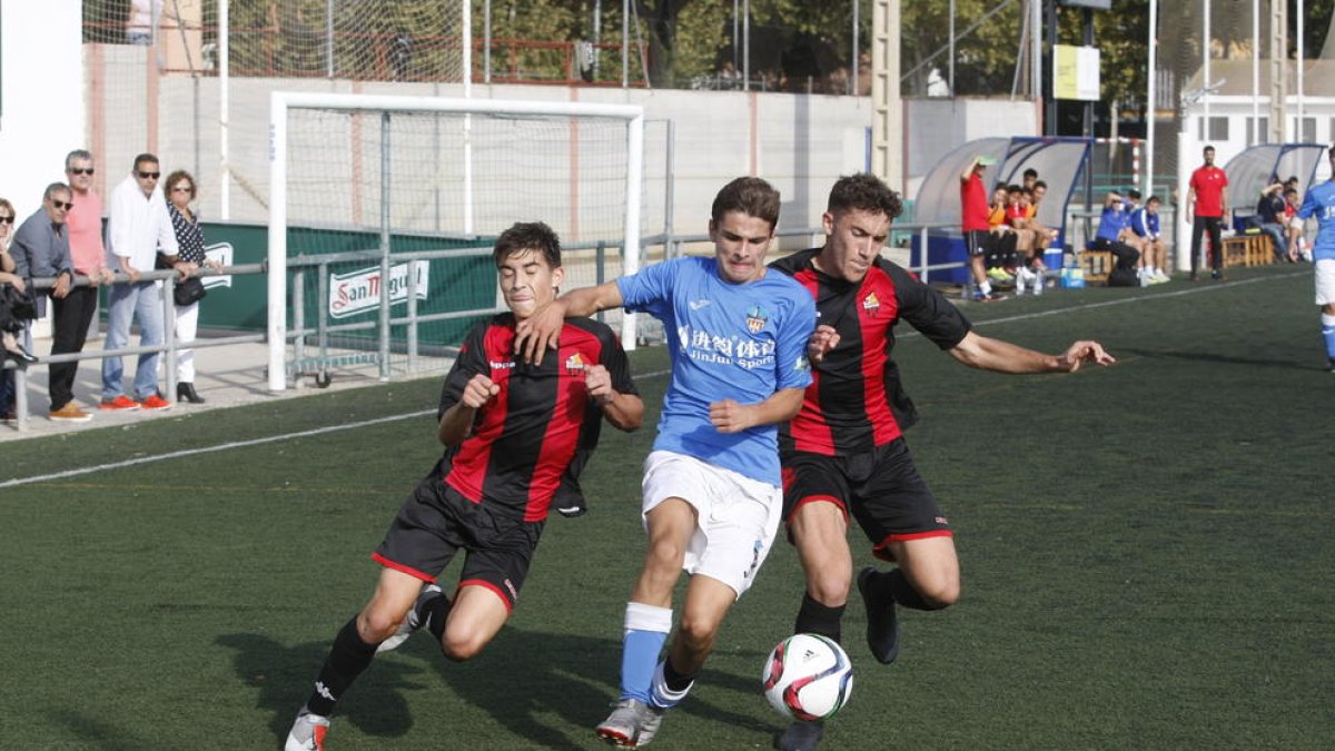 Un jugador del Lleida intenta avanzar ante la oposición de dos futbolistas del Reus.