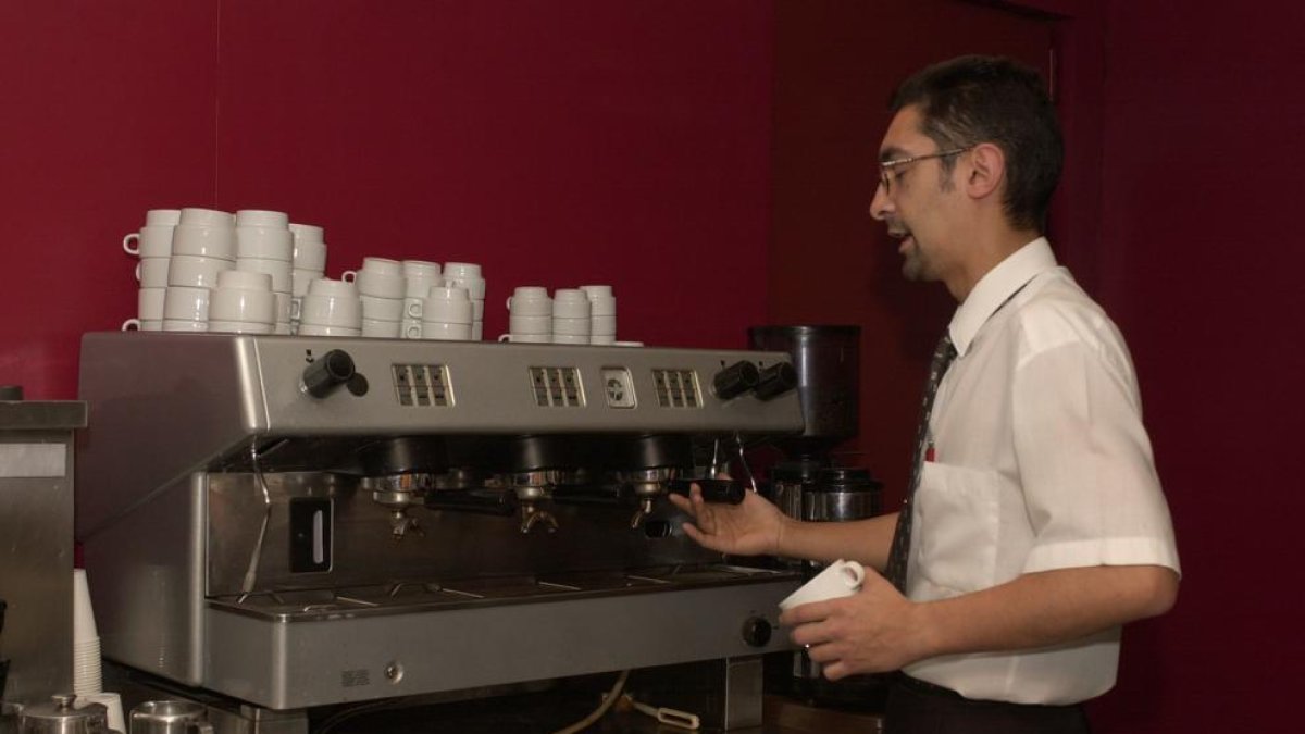 El dueño de un bar, trabajador autónomo, se dispone a preparar un café.