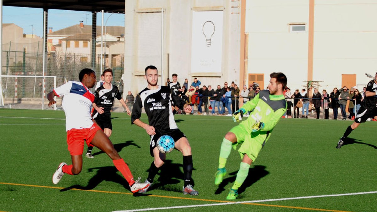 El jugador visitant Pocurull intenta avançar-se al jugador del Linyola, Alpha, que va ser l’autor del gol local que li va donar un punt a l’equip davant del Mollerussa.