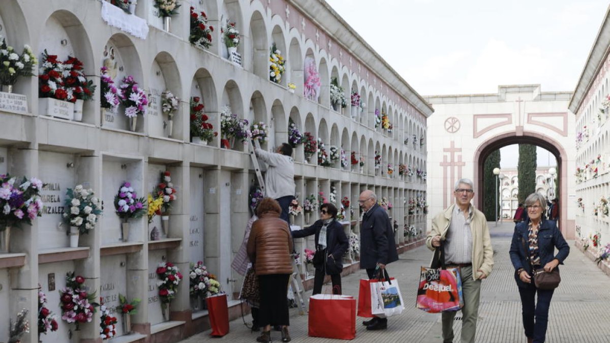 Usuaris ahir al cementiri arreglant les sepultures dels seus familiars abans de Tots Sants.