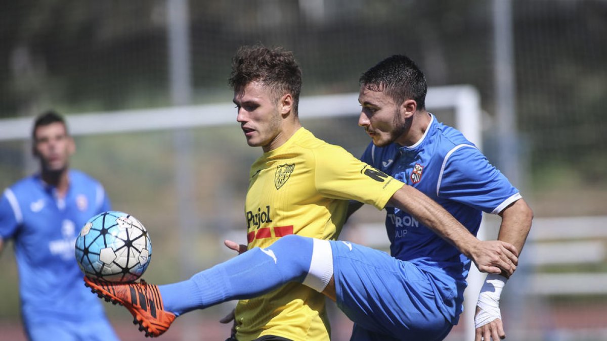 Un jugador del Vista Alegre despeja ante uno del Mollerussa que intentaba controlar el balón.