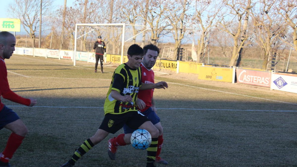 Un jugador de l’Angulària defensa la possessió de l’esfèric davant de la pressió rival.
