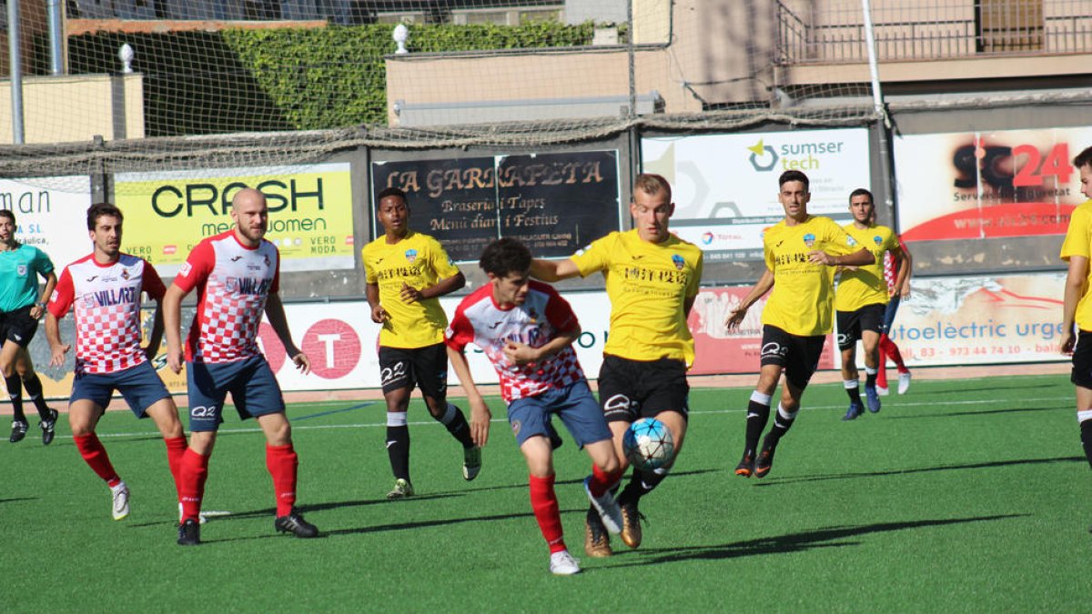Un jugador del Balaguer y otro del Lleida B luchan por la posesión de un balón.