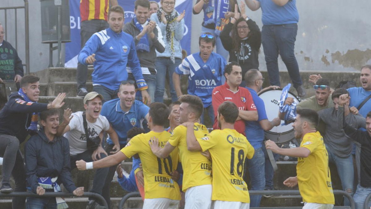 Els jugadors del Lleida celebren el gol de Juanto Ortuño amb els aficionats lleidatans que es van desplaçar fins a Olot.