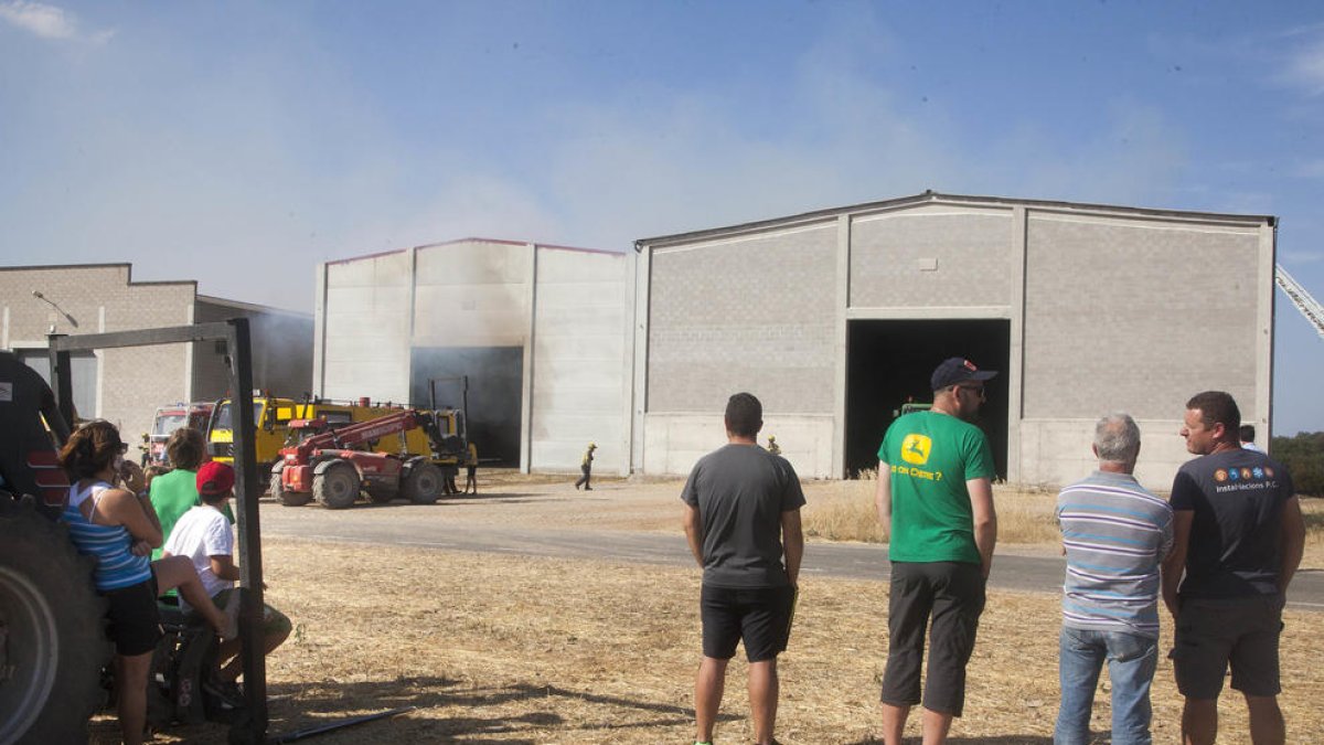 Veïns que es van desplaçar ahir fins a les naus afectades per l’incendi a Sant Ramon.