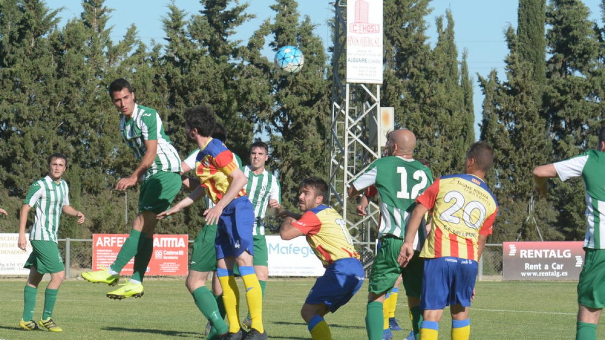 Jugadors de l’Alguaire i del Bellpuig en una disputa de pilota aèria, ahir durant el partit.