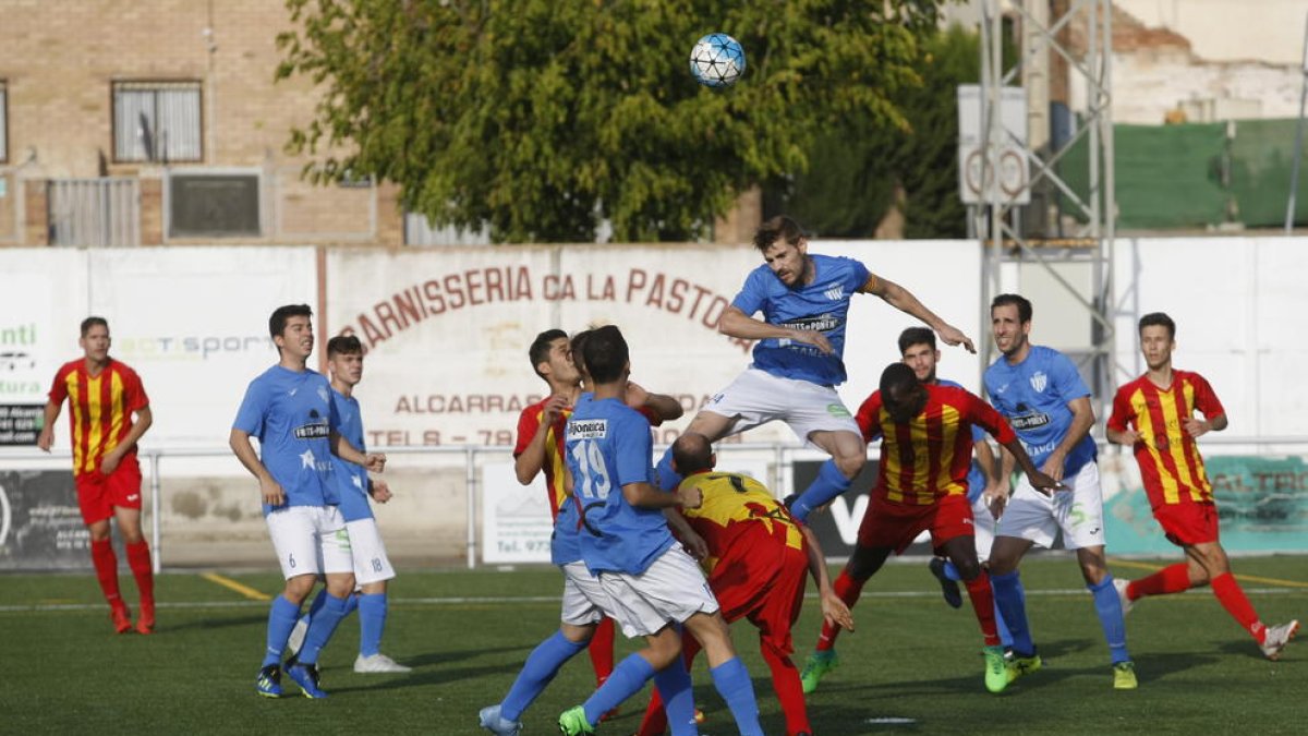 Un jugador del Alcarràs salta por encima de los rivales para rematar un balón en una acción del partido.
