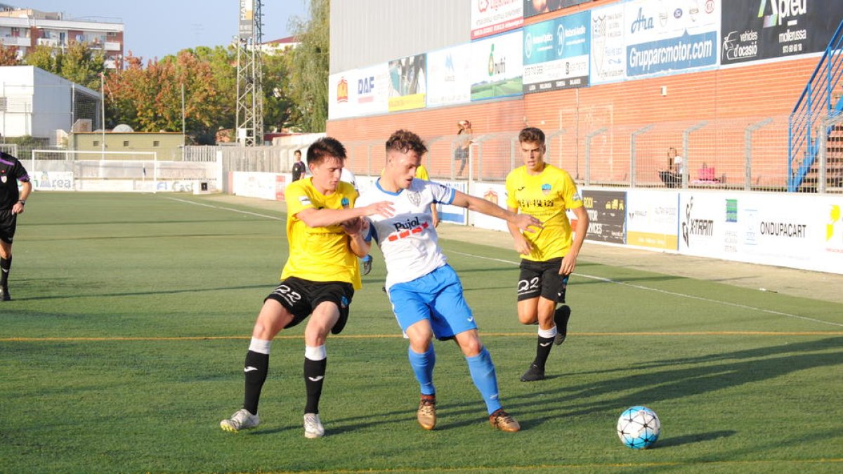 Un jugador del Mollerussa y otro del Lleida pelean por un balón, ayer durante el derbi.