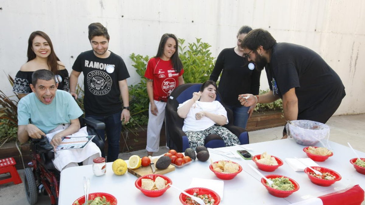 Un estudiant d’Educació Social dona a provar guacamole mexicà a una resident d’Aremi.