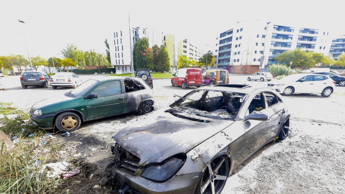 Vista de dos de los tres vehículos calcinados ayer de madrugada en el Passeig Onze de Setembre.